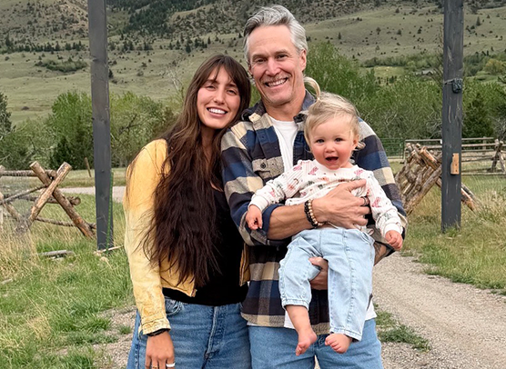 Andrew Welker poses with his wife and baby in a family photo.