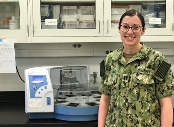 Dr. Megan Schilling, U.S. Navy microbiologist, in her military camouflage uniform inside a naval research laboratory.