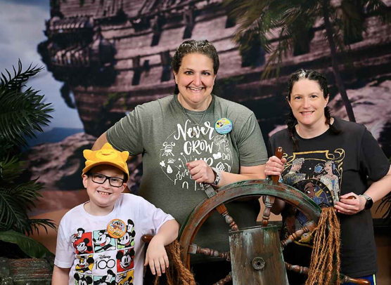 Jillian Frantz, National Board Certified elementary school teacher, poses at a pirate ship-themed classroom display while holding a ship's wheel.