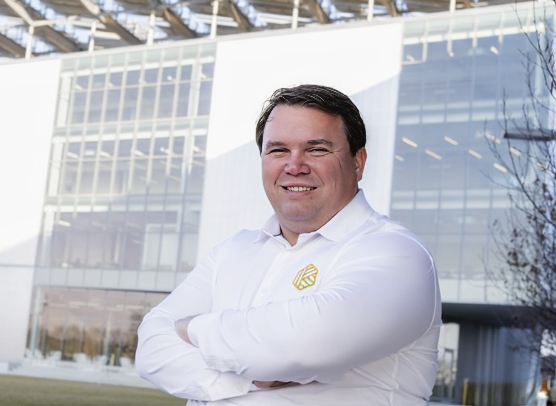 Dr. Tom Darrah, geologist, professor, and clean energy entrepreneur, in a professional portrait outside a research facility.